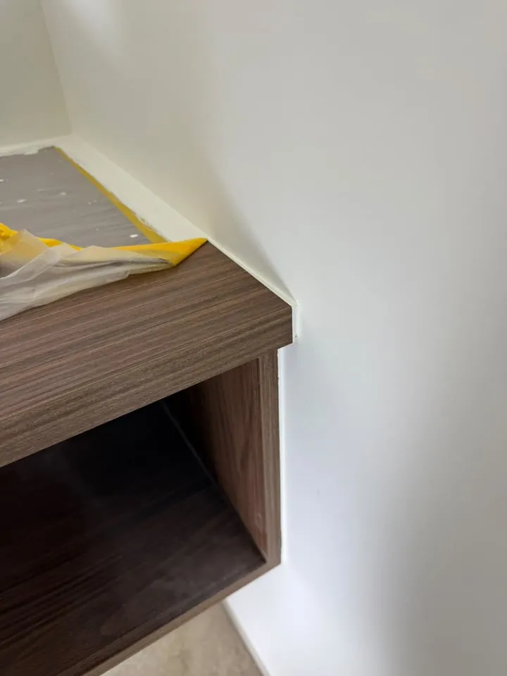 Muurvlak strak afgetekend rond een houten wandmeubel