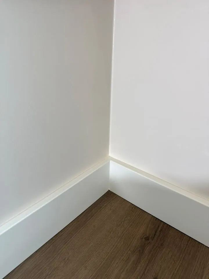 Hoek en plint strak afgewerkt tegen een houten vloer