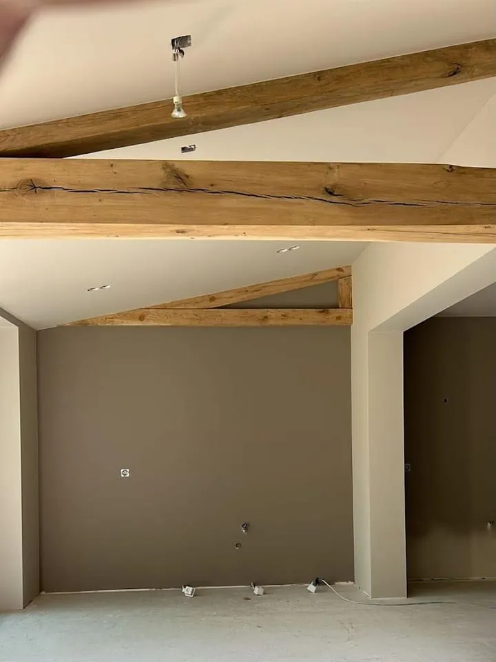 Taupe wand onder eiken balken