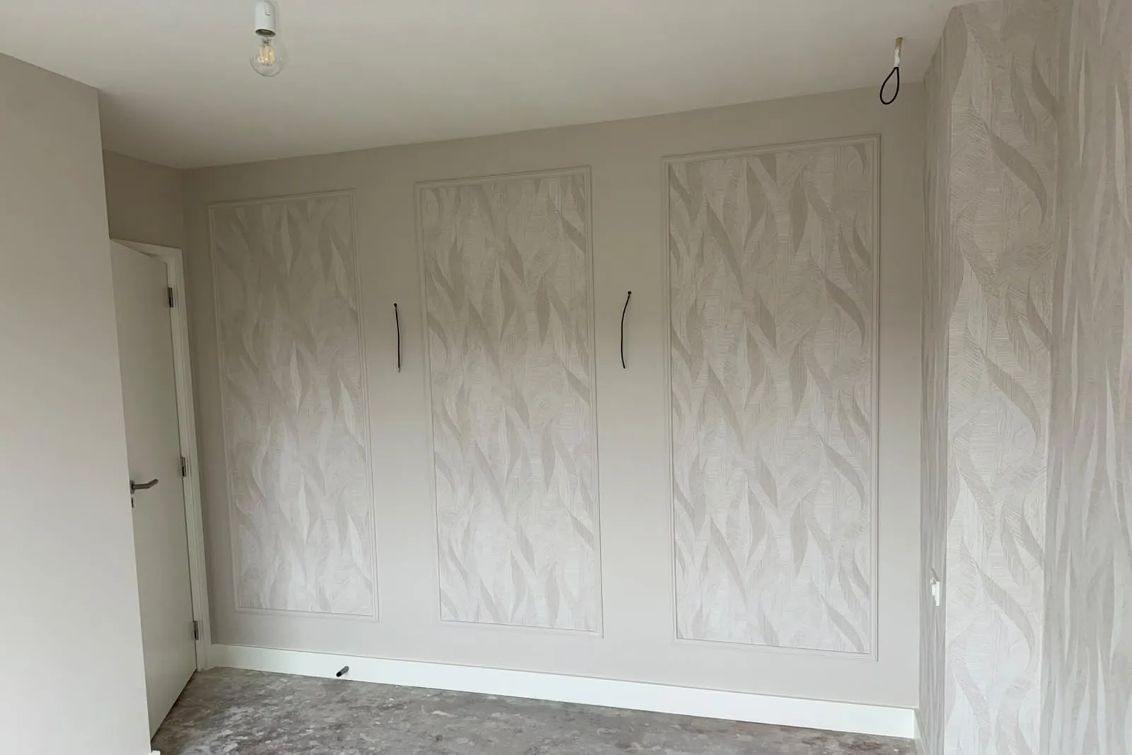 Drie panelen behang met bladmotief in lijstwerk, met de zijwand helemaal behangen