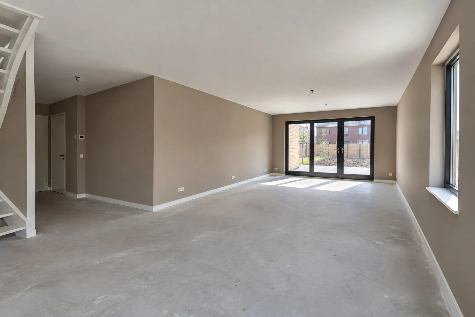 Benedenverdieping van een nieuwbouwwoning in Berghem met taupe geschilderde wanden, een wit plafond en witte plinten